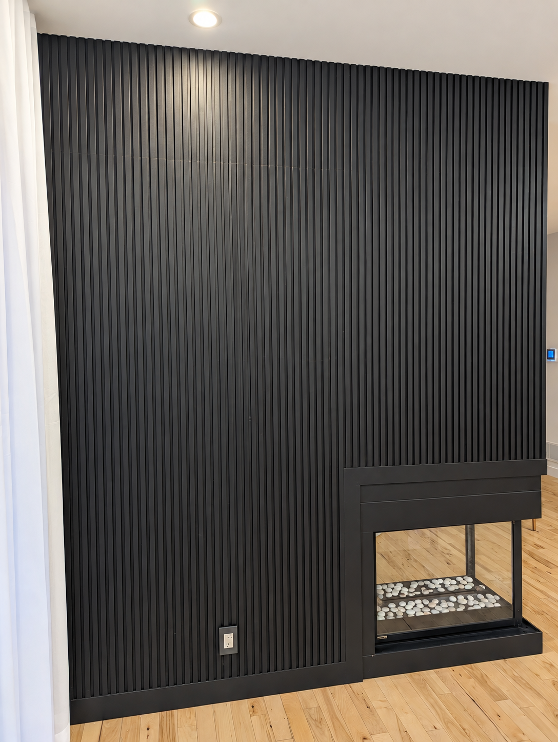 Detail of the black fireplace cladding — Sainte-Julie.